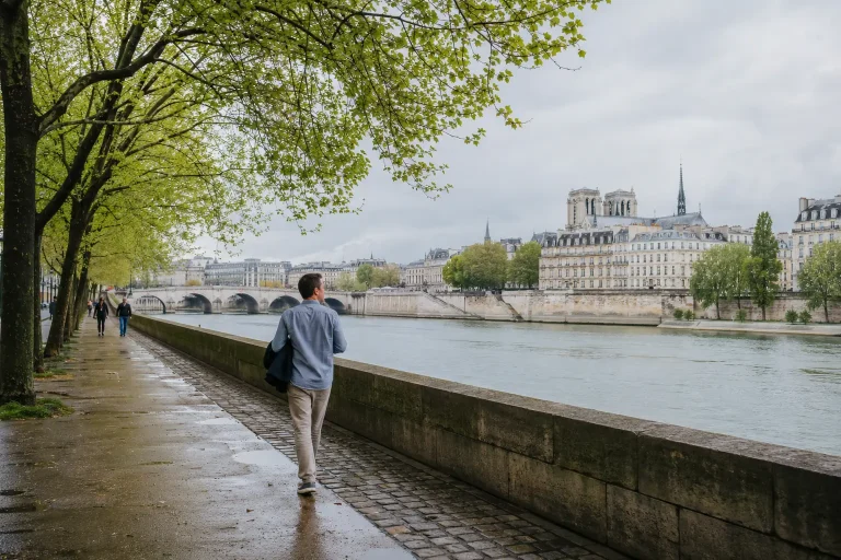 Traveler walking beside the Seine on a mild late-spring morning in Paris