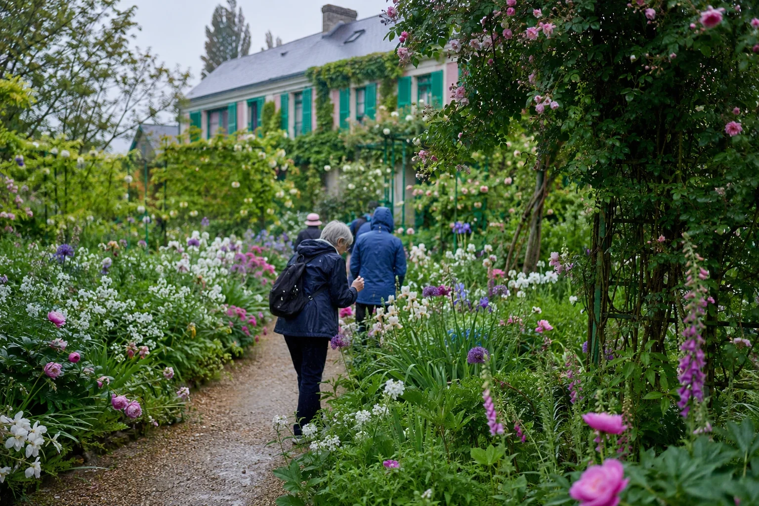 Visitors walking through Monet's flower garden in Giverny after light rain