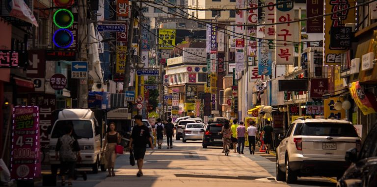 Young people walking through a lively Seoul street