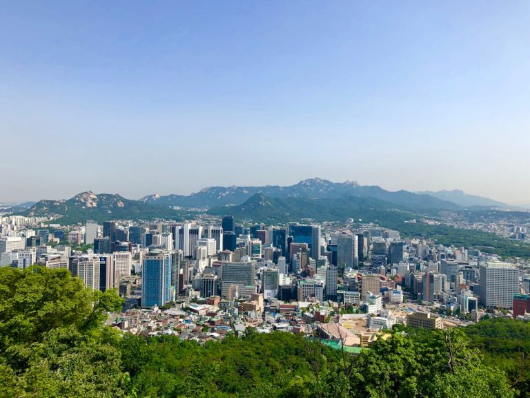 Wide view of Seoul with mountains beyond the city
