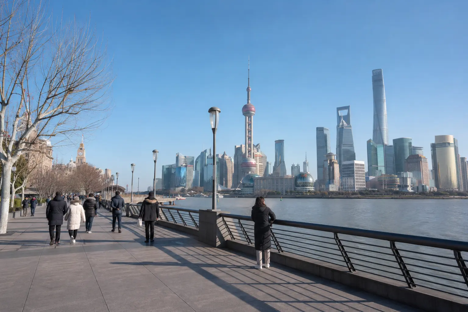 Bund pedestrians in winter coats beneath a clear Shanghai sky