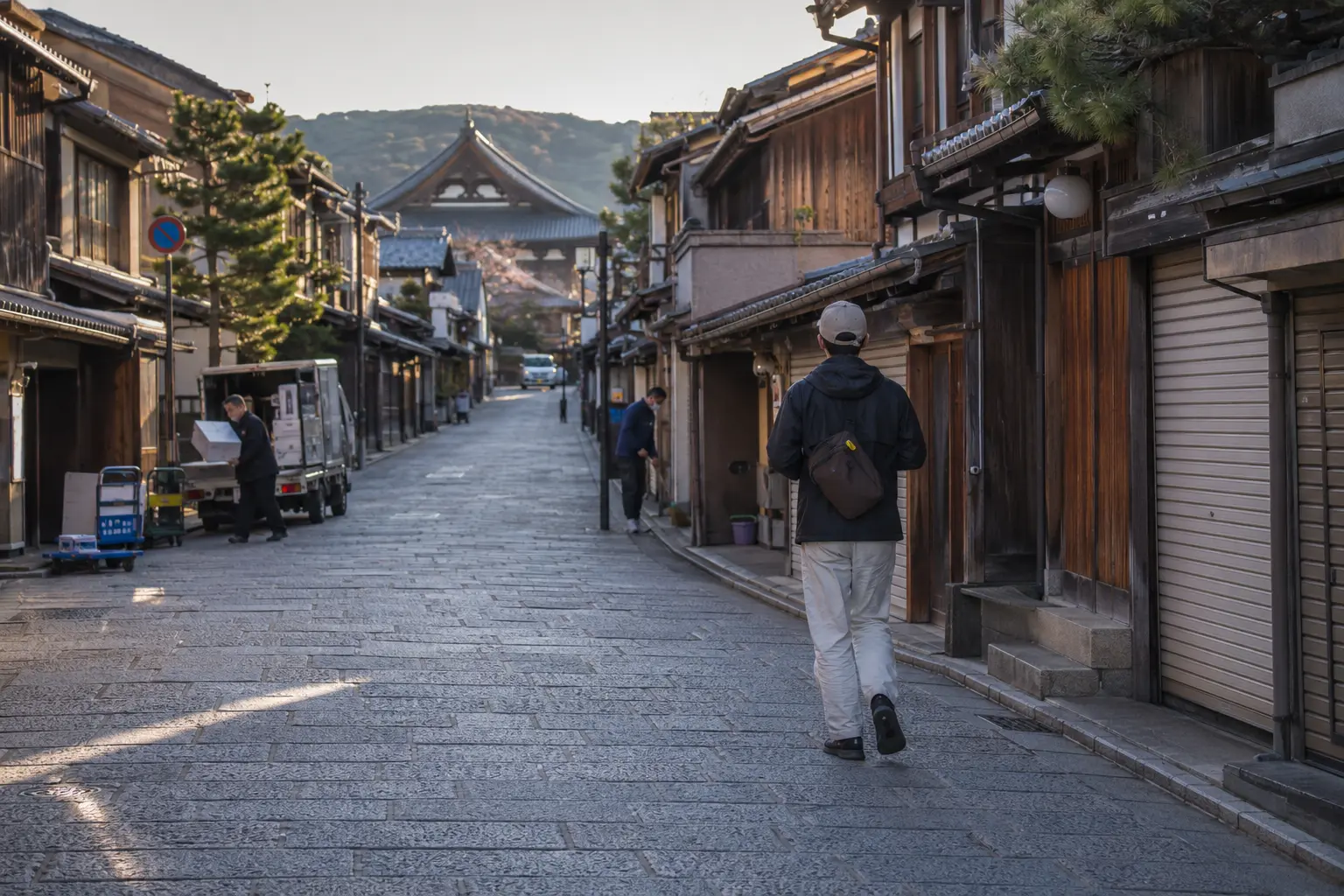 Traveler walking through Southern Higashiyama early in the morning as shops open