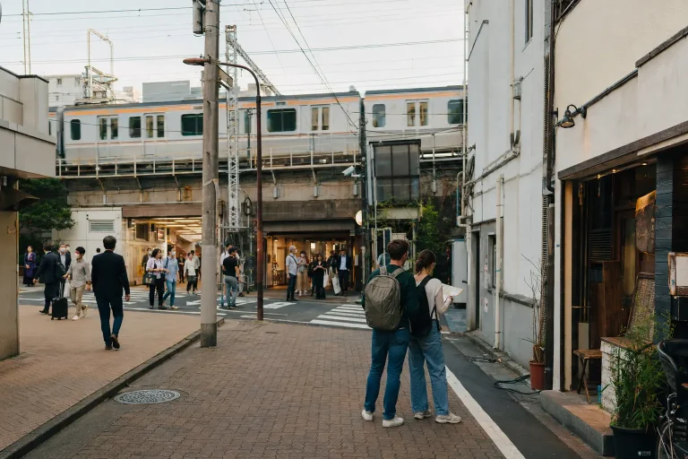 Travelers orienting themselves on a Tokyo side street beside a railway station