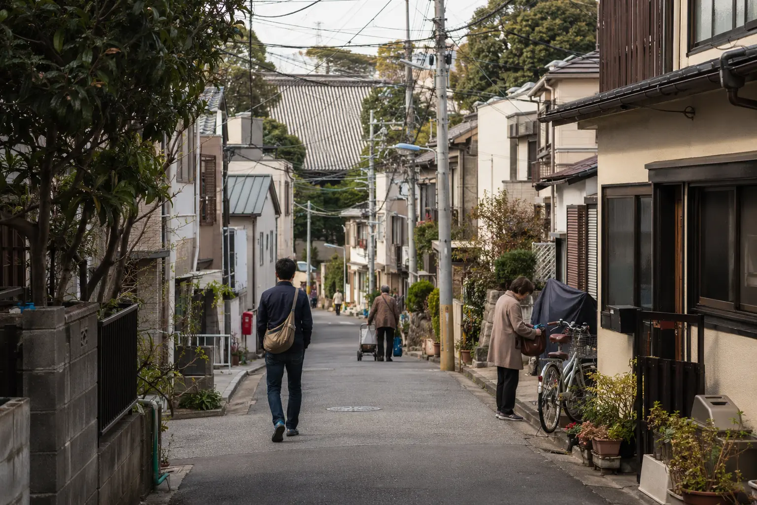 Traveler walking through a quiet residential lane in the Yanesen area of Tokyo