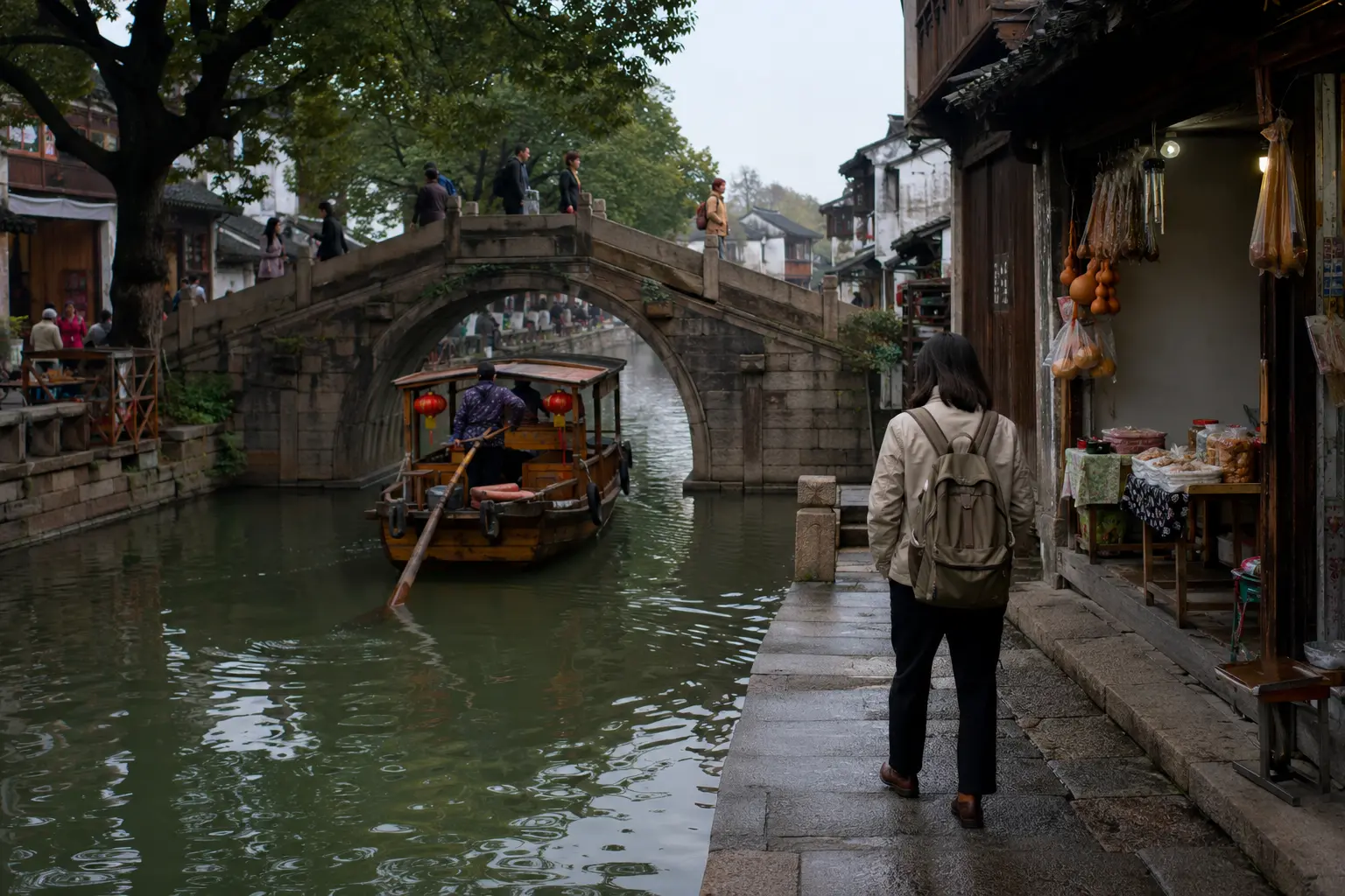 Traveler walking beside a canal and stone bridge in Zhujiajiao
