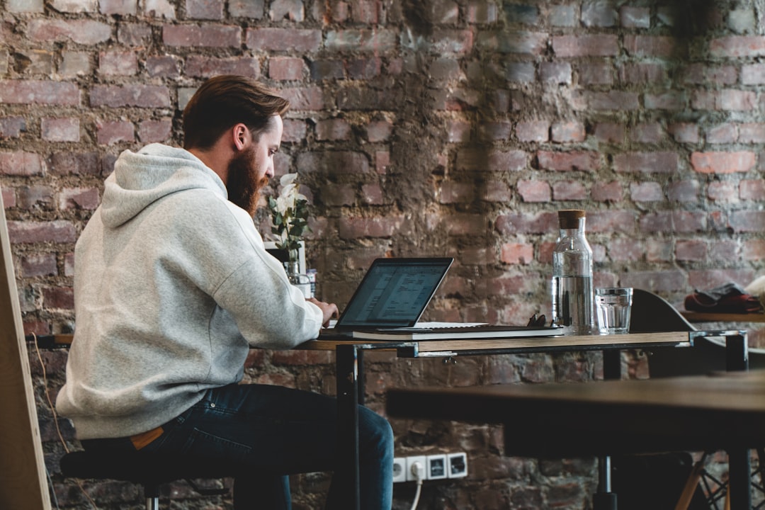man in beige hoodie sitting on chair using laptop computer — How to Become a Digital Nomad: A Complete Beginner’s Guide
