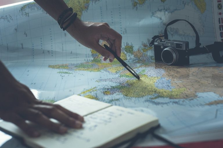 person writing on white paper — digital nomad health insurance