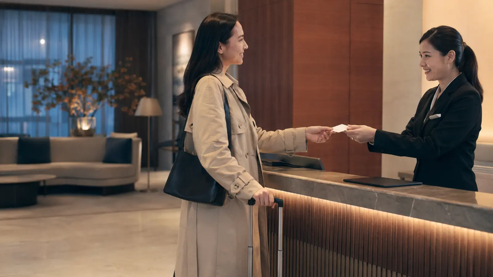 Solo traveler checking in at a staffed hotel reception desk