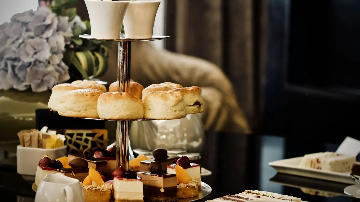 Tiered British afternoon tea stand with scones, small cakes and finger sandwiches