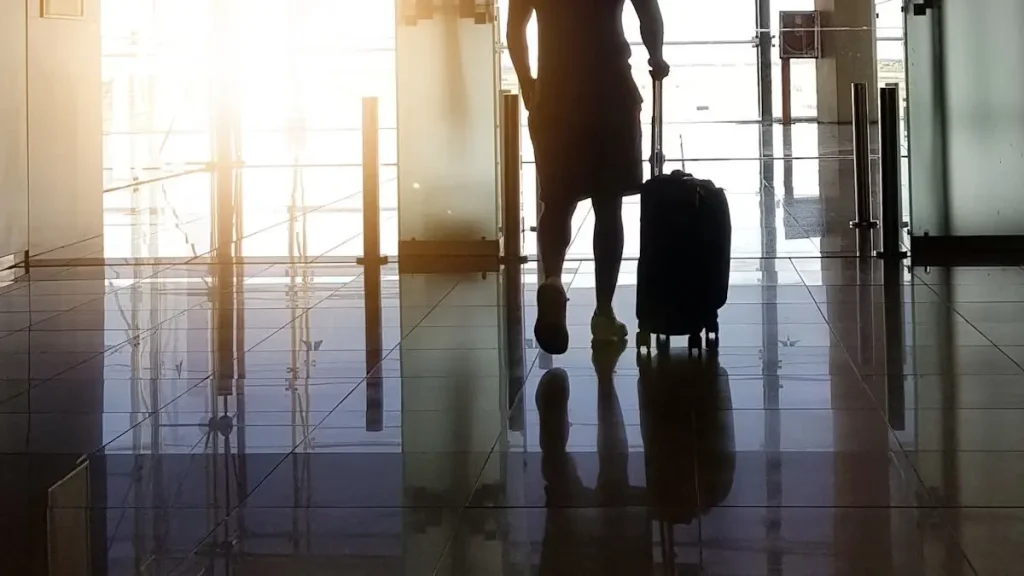Traveler pulling a suitcase through an airport terminal