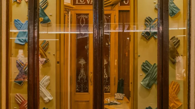 Colorful gloves arranged in glass display windows at a vintage shop in Lisbon's Chiado district