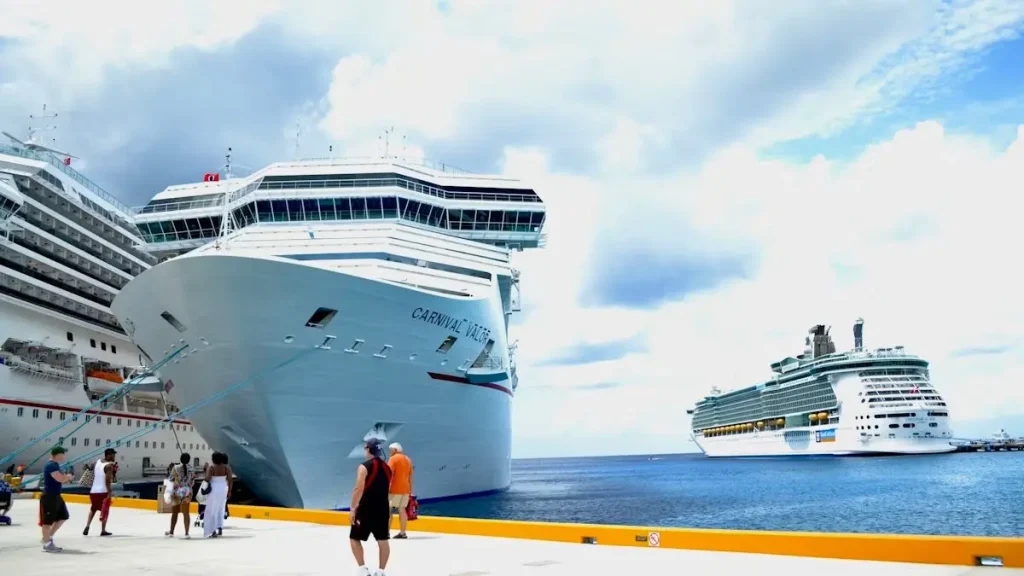White cruise ship docked beside calm blue water