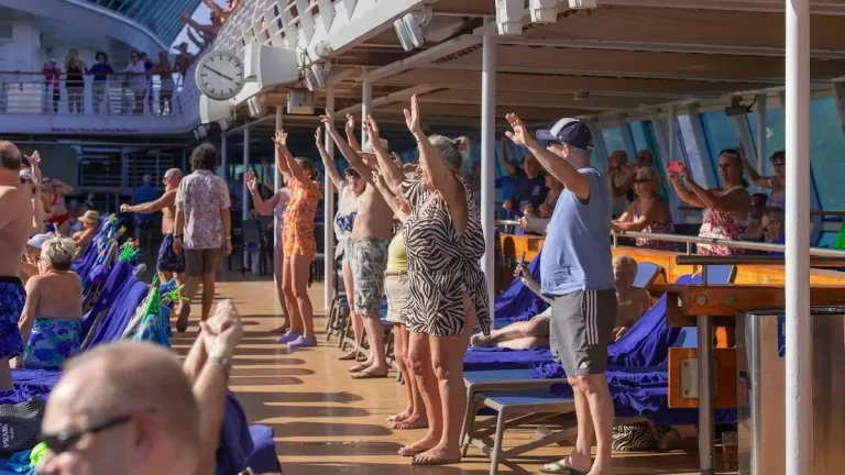 Cruise passengers joining a group activity on the ship’s pool deck