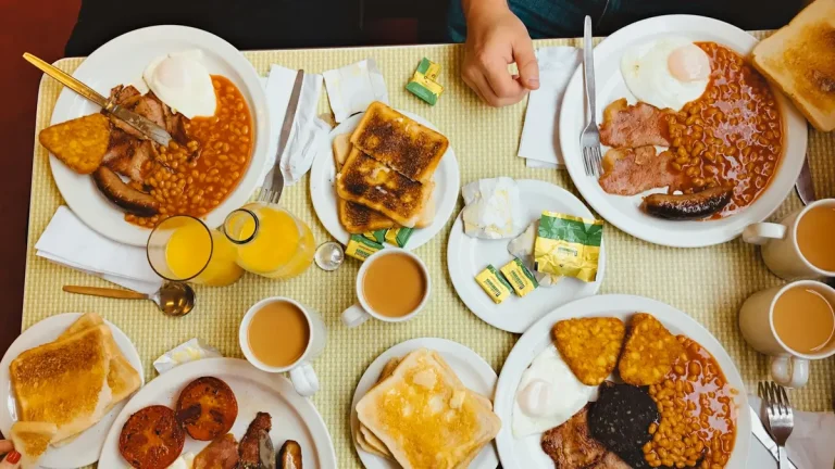 Full English breakfasts with eggs, bacon, sausages, beans, toast and black pudding on a cafe table in Westminster