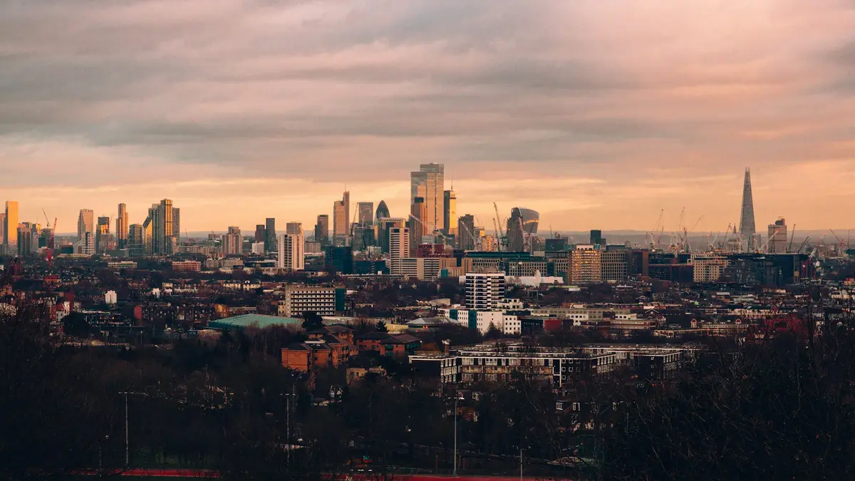 London skyline beneath pink evening clouds viewed from Hampstead Heath