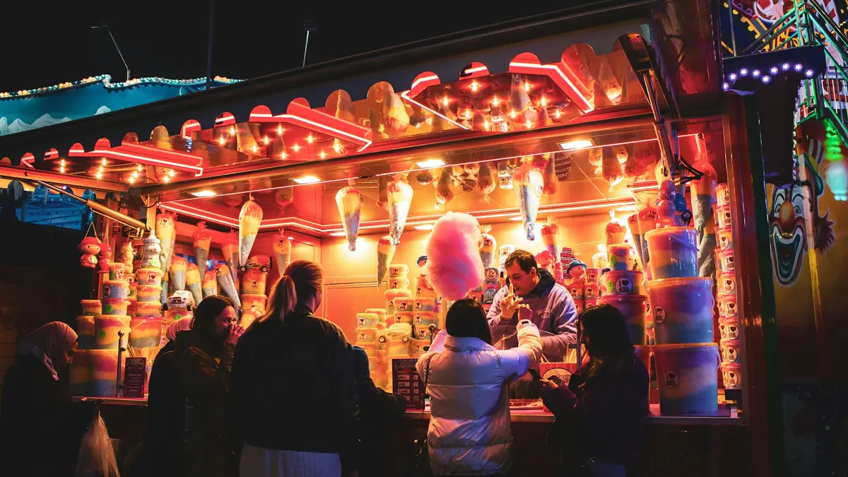 Visitors near illuminated attractions at Hyde Park Winter Wonderland in London