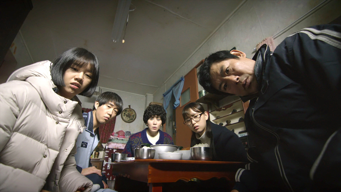 Reply 1988 family gathered around a low dining table