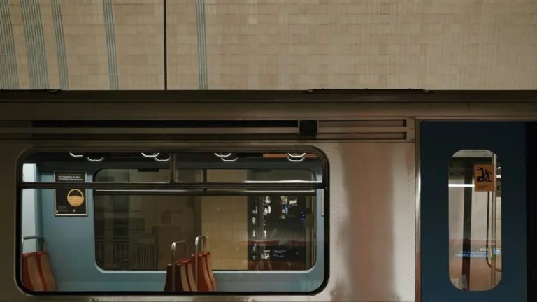 Side view of a Lisbon Metro car beside a tiled underground station wall
