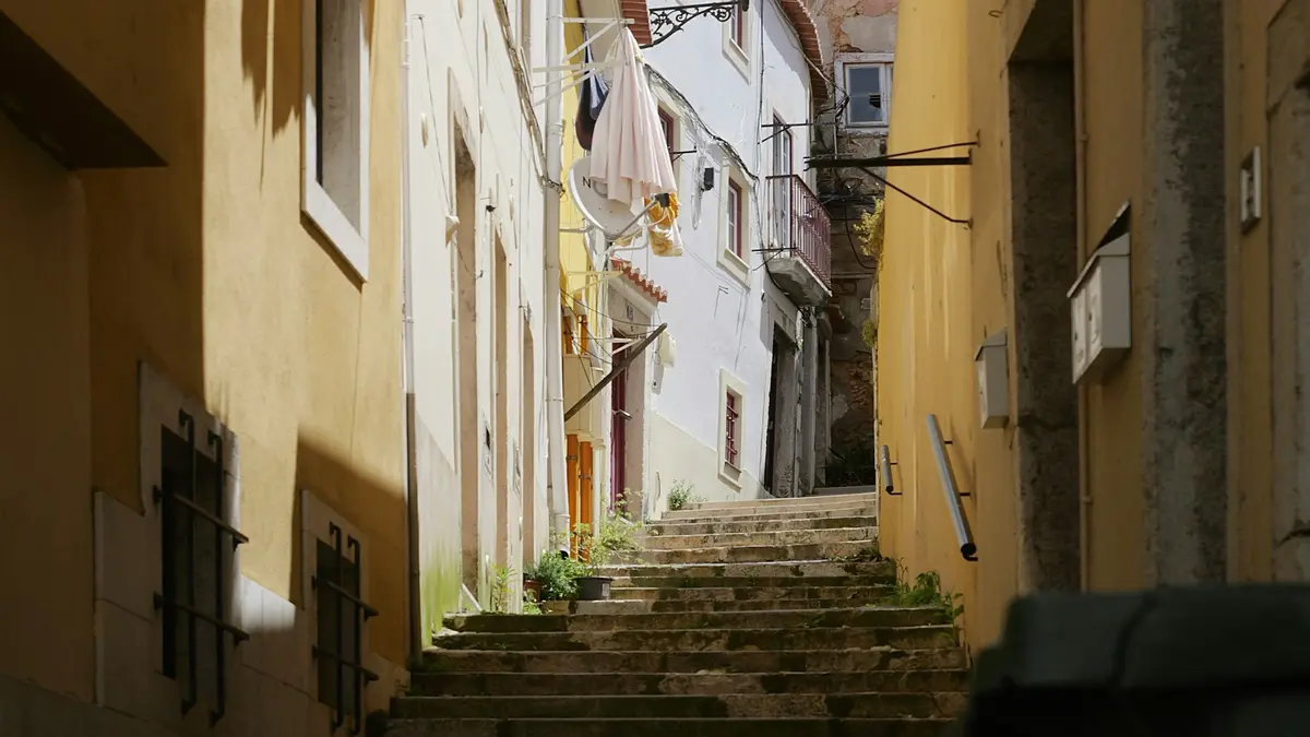 Steep stone steps between narrow residential buildings in Lisbon