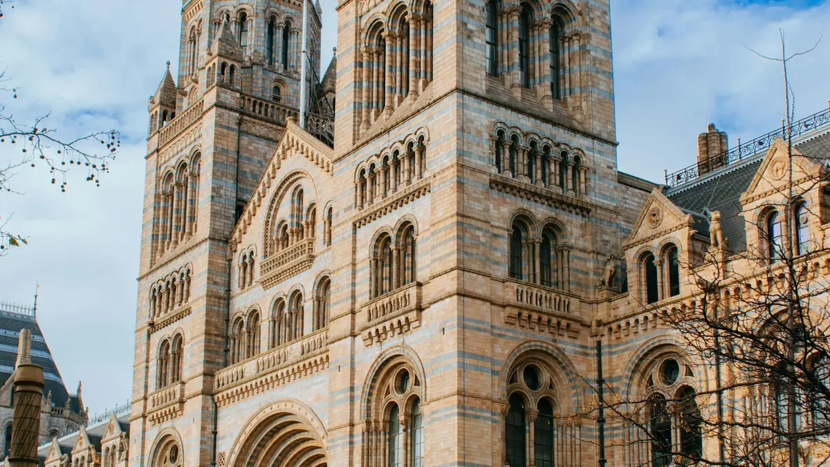 Arched windows and striped stone towers on the Natural History Museum exterior in London