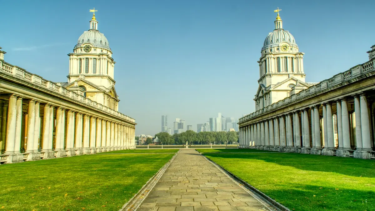 Twin domes and colonnades of the Old Royal Naval College framing a distant London skyline