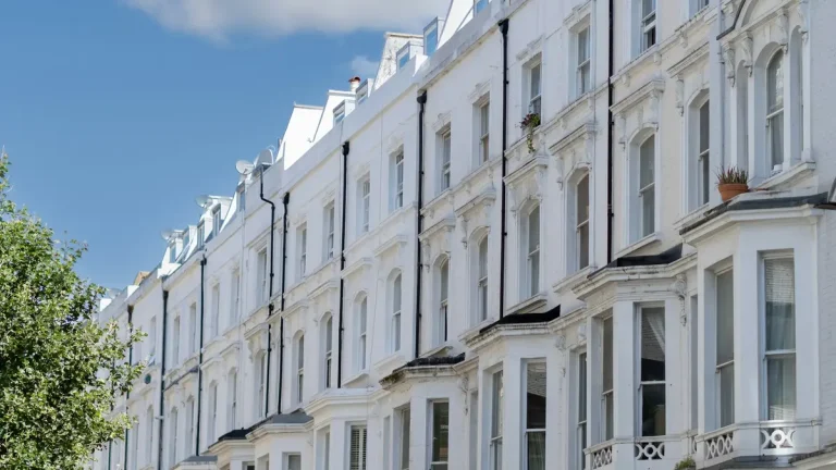 Row of white Victorian terraced houses in Paddington under a blue sky