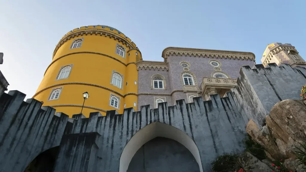 Yellow tower and patterned stone walls of Pena Palace in Sintra