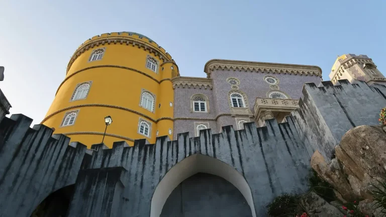 Yellow tower and patterned stone walls of Pena Palace in Sintra