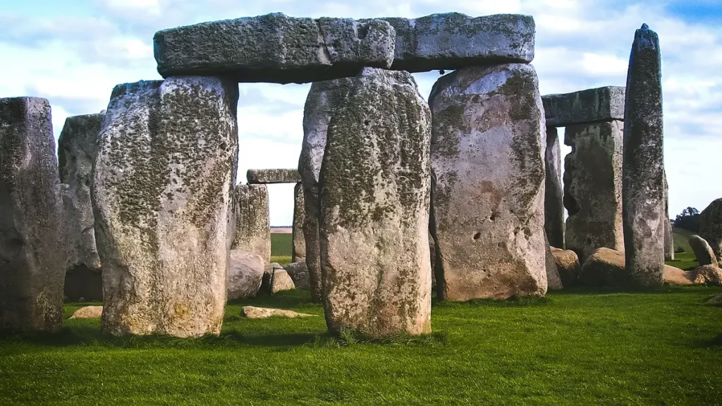 Stone uprights and lintels at Stonehenge above green grass in Wiltshire