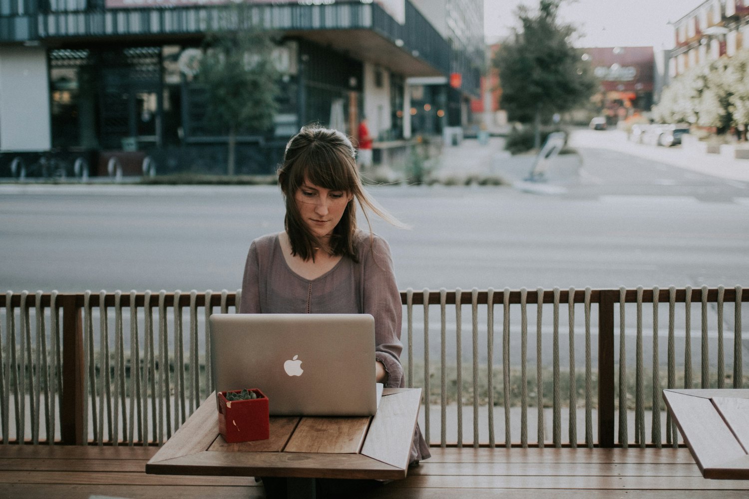 A person working on a laptop at an outdoor café table