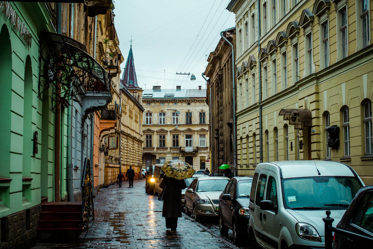 A person with an umbrella on a wet European street