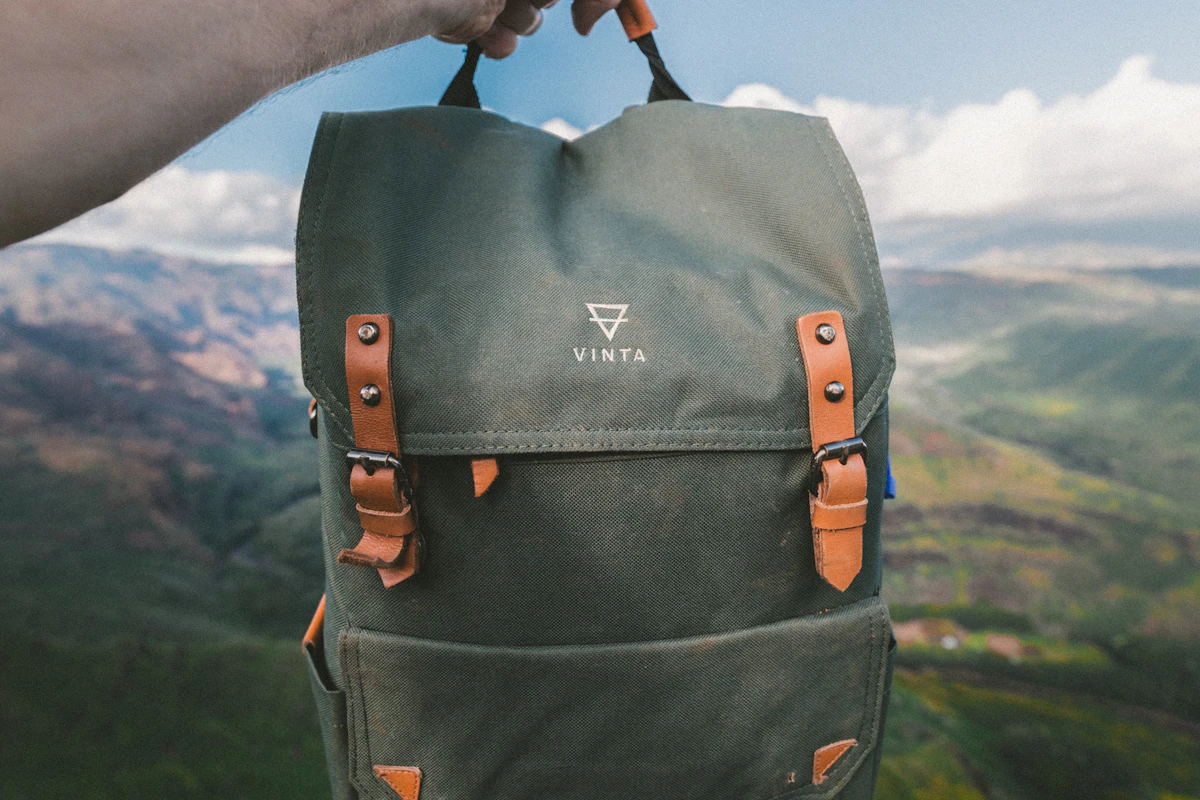 A traveler holding a canvas travel backpack
