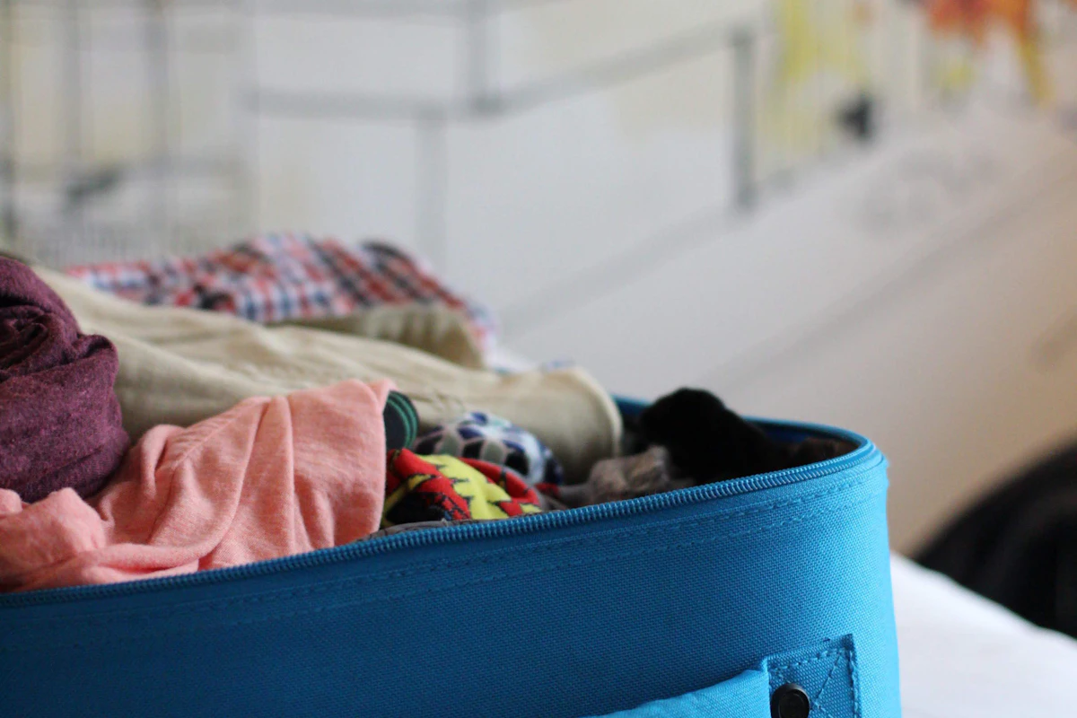 Suitcase packed with folded summer clothes for a resort week