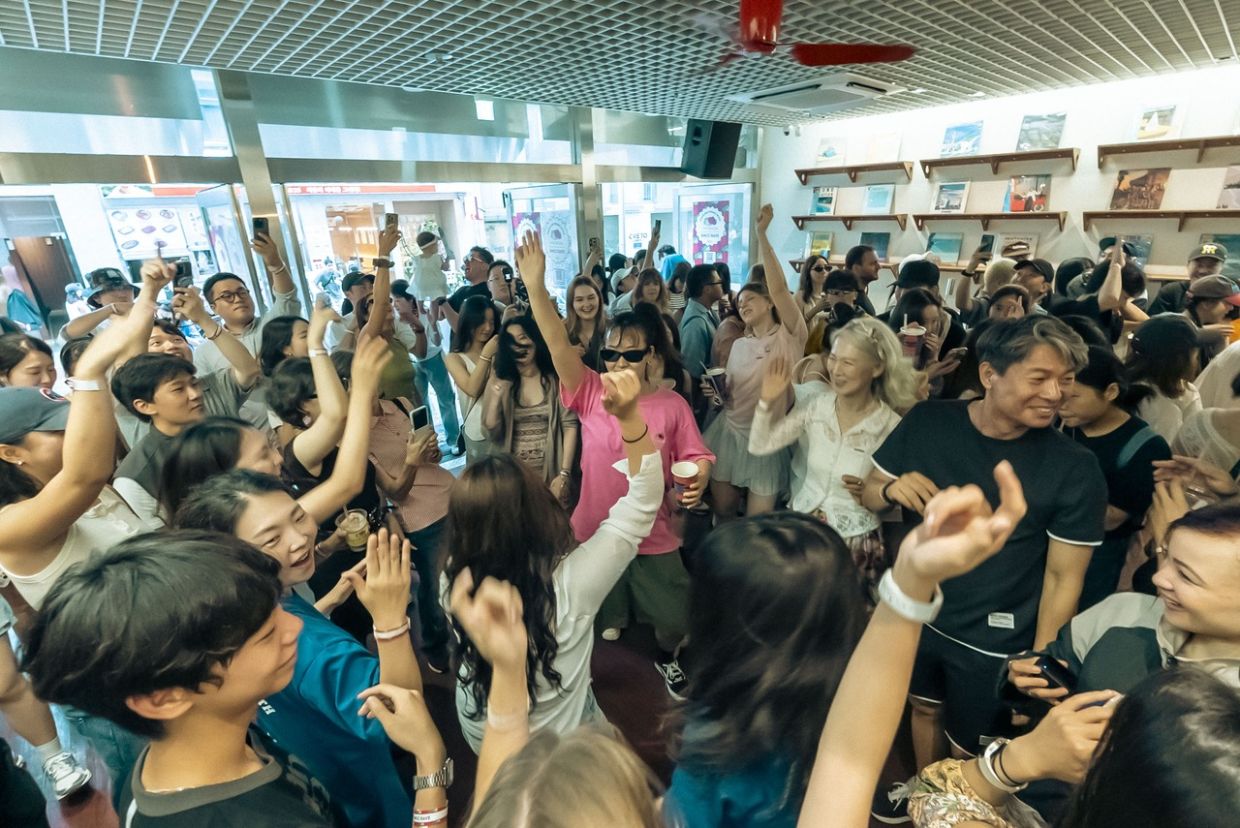 Crowd dancing at a morning rave inside a Seoul café
